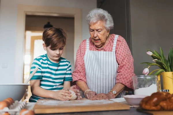 손자와 할머니는 전통적인 부활절 식사를 부활절 크로스 반죽을 요리법 사용자 — 스톡 사진