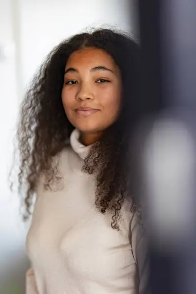 Portrait of beautiful curvy woman in turtleneck, with beautiful curly hair, looking at camera.