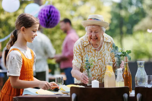Girl Helping Grandmother Set Table Summer Garden Party Bringing Plates — Stock Photo, Image