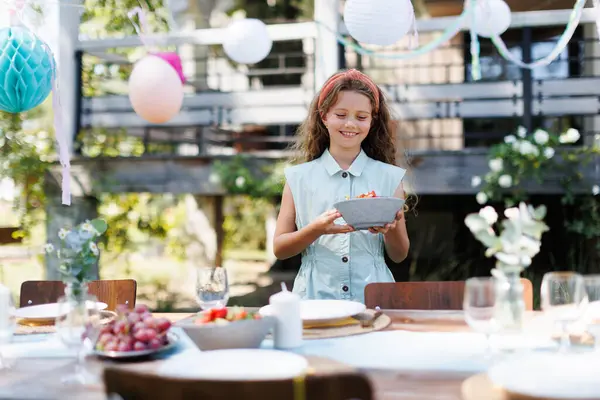 Κορίτσι Βοηθώντας Στρώσετε Τραπέζι Για Καλοκαιρινό Πάρτι Στον Κήπο Φέρνοντας — Φωτογραφία Αρχείου