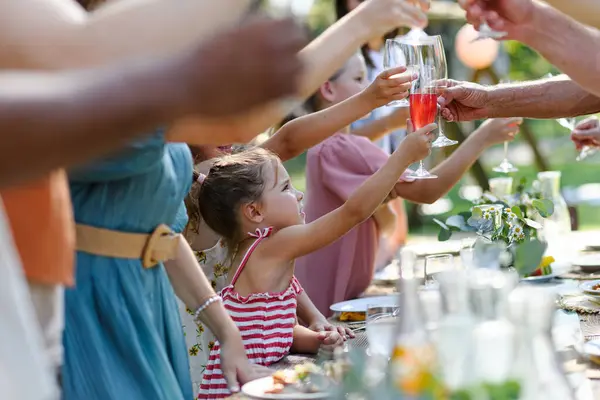 夏のガーデンパーティーでメガネを飲む家族 ノンアルコールの飲み物で飲んでいる子供 レモネード テーブルで乾杯する ビッグファミリーガーデン Bbq — ストック写真