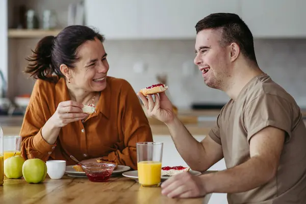 Jongeman Met Het Syndroom Van Ontbijt Met Zijn Moeder Thuis — Stockfoto
