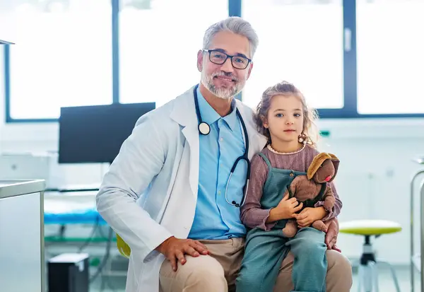 小児科医の肖像画 膝の上に座っている少女の患者 医師と子供の患者との友好的な関係 — ストック写真