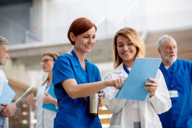 Doktorlar eşsiz ameliyat başarısını tartışıyor, koridorda yürüyorlar. Meslektaşlar, doktorlar hasta teşhisini tartışıyor. Modern hastanede, klinikte.