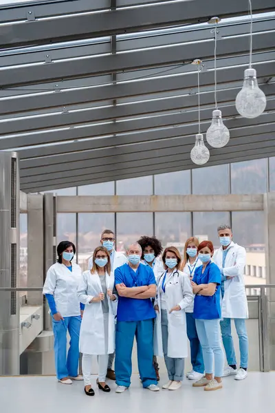 Doctors in surgical masks. Healthcare team with doctors, nurses, professionals in medical uniforms with face masks in hospital, modern clinic.