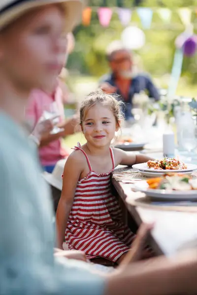 屋外でグリルした食べ物を食べるテーブルに座っている美しい少女の肖像画 ファミリーガーデンパーティーの少女 — ストック写真