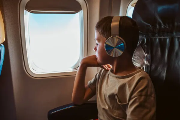 Anak Dengan Headphone Duduk Pesawat Melihat Luar Jendela Konsep Terkenal — Stok Foto