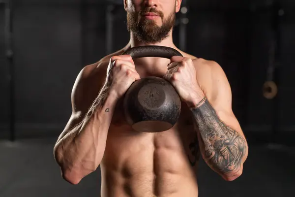 一个人把哑铃紧紧地放在他那裸露的肌肉胸前 促进身心健康的日常锻炼 — 图库照片