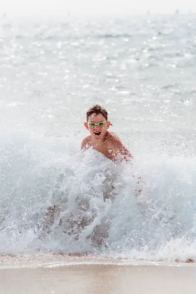 Młody Chłopiec Bawiący Się Biegający Pluskający Silnymi Falami Morskimi Uśmiechnięty Obraz Stockowy