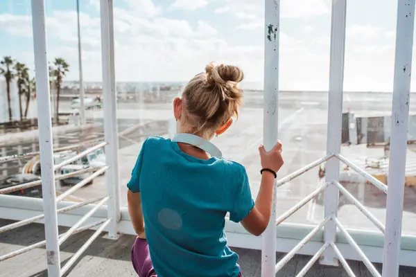 空港の窓からバケーション先を眺め 海とビーチに興奮する少女 ロイヤリティフリーのストック写真