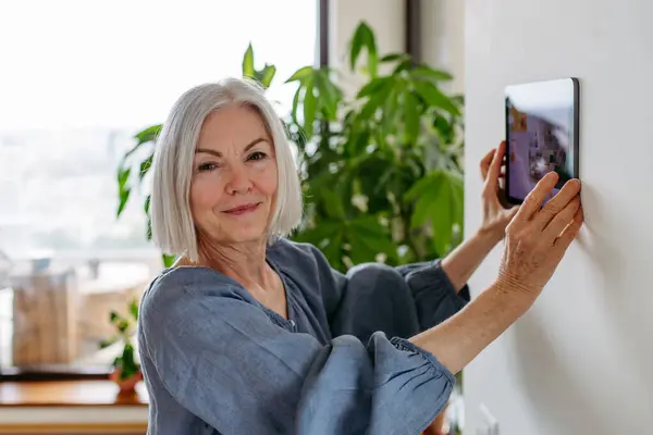 Starší Žena Nastavuje Funkce Domácnosti Osvětlení Bezpečnostní Kamery Zámky Dveří Royalty Free Stock Obrázky