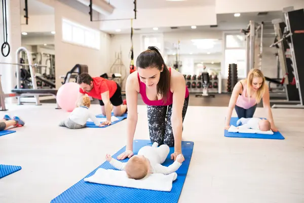Mother Smiling Baby While Performing Exercise Her Group Exercise Class Stock Picture