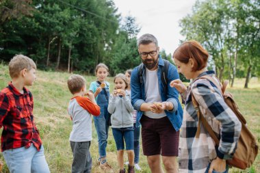 Eğitim sırasında çocuklara atıştırmalık bir şeyler ver. Açık havada aktif eğitim, genç öğrencilerin ekosistem hakkında öğrenmelerine yardımcı oluyor.