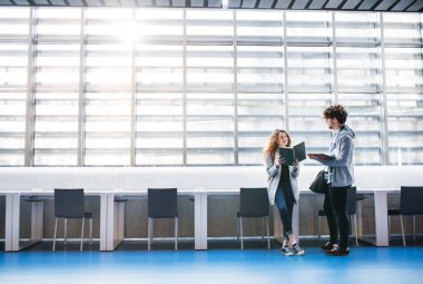 Kütüphanede toplanan genç üniversite öğrencileri final sınavına ya da sunuma hazırlanıyorlar. Takım çalışması becerileri.