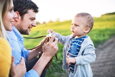 Yeni anne-babalar küçük bebeklerin resmini çekiyor, bebeğim. Bahar doğasında açık havada. Mutlu aile anları.