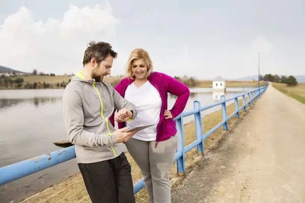 Overweight Woman Resting Run Personal Trainer Checking Her Profile Performance Stock Photo