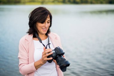 Tatildeki güzel olgun kadın portresi. Profesyonel kamerayla fotoğraf çekmek, doğadaki güzellikleri yakalamak..