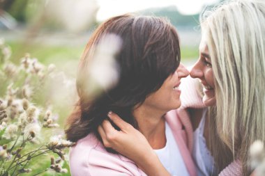 Yetişkin kız, annesiyle dışarıda vakit geçiriyor. Güzel kız birbirine sevgiyle sarılıyor. Koşulsuz, derin anne sevgisi, Anneler Günü konsepti.