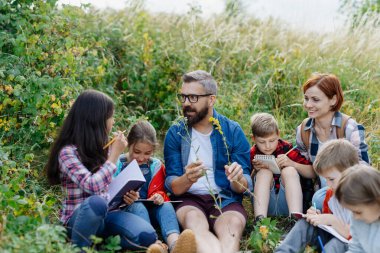 Genç öğrenciler doğayı, biyoloji dersi sırasında orman ekosistemini öğreniyorlar, yabani bitkileri gözlemliyorlar. Açık hava eğitimi sırasında öğretmenlik yapmaya adanmıştır. Öğretmenler Günü.