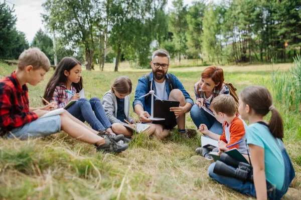 Öğrenciler saha dersi sırasında yenilenebilir rüzgar enerjisini öğreniyorlar. Açık havada aktif eğitim, genç öğrencilere ekoloji ve sürdürülebilirlik, çevre koruma hakkında bilgi vermektedir..