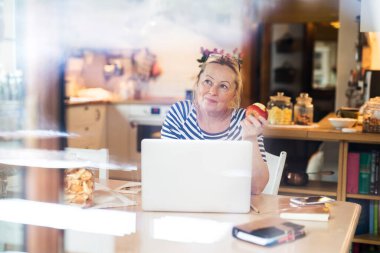 Merkez büroda çalışan yaşlı bir kadın. Emekliler emekliliklerinde fazladan para kazanıyor. İnternet faturalarını ödeyen kadın