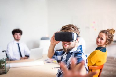 Bir şirket ofisinde VR teknolojisini kullanan bir grup genç iş arkadaşı. İş dünyasında sanal gerçeklik.