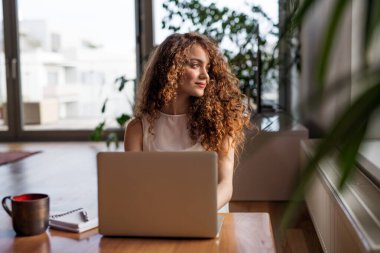 Beautiful woman working on laptop at home, homeoffice for young worker. Student studying at home, preparing for final exam in university. clipart