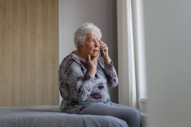 Üst düzey kadın evde yalnız vakit geçirmek için telefon görüşmesi yapıyor. Yalnızlık ve emeklilerin bağımlılığı kavramı.