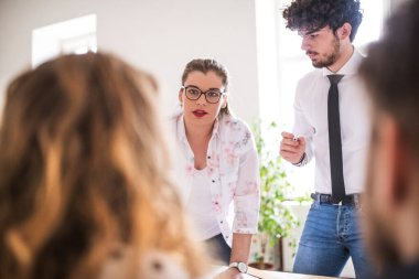Girişim şirketinin ofisinde yeni bir proje üzerinde tartışan genç meslektaşlar grubu.