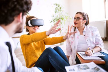 Bir şirket ofisinde VR teknolojisini kullanan bir grup genç iş arkadaşı. İş dünyasında sanal gerçeklik.