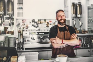 Kahve dükkanında çalışan yakışıklı erkek barmen, tezgahın yanında duruyor, bar. Önlüklü barmen kahve hazırlıyor..