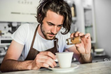Kahve dükkanında çalışan yakışıklı barista, kahve hazırlıyor. Bir kafede yarı zamanlı çalışan üniversite öğrencisi..