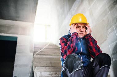 Yaşlı işçi baş ağrısı çekiyor. Felç belirtileri. Şiddetli baş ağrısı gibi migren, zonklayan baş ağrısı.