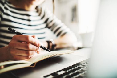 Kafede uzaktan çalışan bir kadın. Cappucino ve laptop masada. Kafede bir defter üzerinde çalışan serbest çalışan bir kadın..