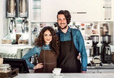 Kahve dükkanında tezgahta bekleyen iki genç barmen. Üniversite öğrencileri bir kafede yarı zamanlı çalışıyorlar..