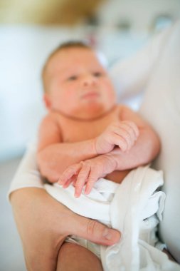 Anne kucağında bebek, bebeğe sevgiyle bakıyor. Koşulsuz baba sevgisi, Anneler Günü.