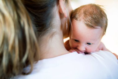 Anne kucağında bebek, bebeğe sevgiyle bakıyor. Koşulsuz baba sevgisi, Anneler Günü.