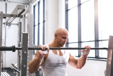 Spor salonunda egzersiz yapan güçlü bir adam. Dinleniyor. Fiziksel ve zihinsel sağlık için rutin çalışma.