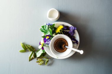 Bir fincan sıcak espresso, üstünde de güzel bir çiçek..