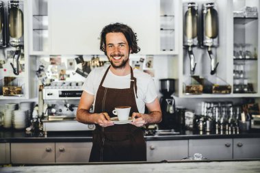 Kahve dükkanında çalışan yakışıklı barista, kahve hazırlıyor. Bir kafede yarı zamanlı çalışan üniversite öğrencisi..
