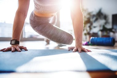 Güzel kızıl saçlı kadınlar evde spor yapıyor. Oturma odasında spor salonundaki spor salonunda spor kıyafetleri giyen bir kadın..