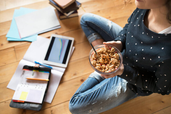 Студентка сидит на полу, читает книги, готовится к выпускному экзамену в университете. Студент дома.