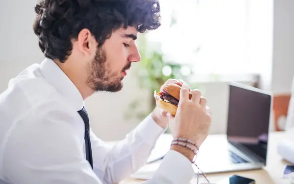 stock image Businessman having quick lunch, fastfood meal in startup company office.