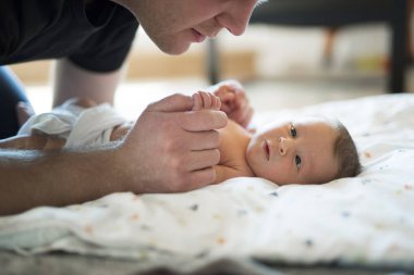 Baba yeni doğmuş kızına bakıyor. Koşulsuz baba sevgisi ve Babalar Günü konsepti.