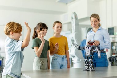 İlkokulda robotik öğrenen çocuklar. Okul sonrası robotlar yapan genç öğrenciler. Gerçek robotik laboratuvarına saha gezisi.
