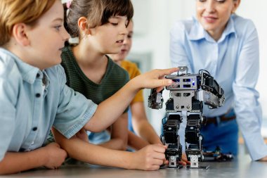 İlkokulda robotik öğrenen çocuklar. Okul sonrası robotlar yapan genç öğrenciler. Gerçek robotik laboratuvarına saha gezisi.