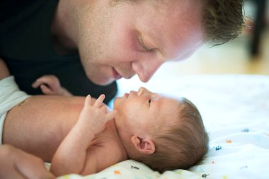 Baba yeni doğmuş kızına bakıyor. Koşulsuz baba sevgisi ve Babalar Günü konsepti.