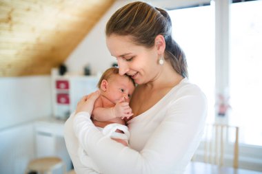 Anne kucağında bebek, bebeğe sevgiyle bakıyor. Koşulsuz baba sevgisi, Anneler Günü.