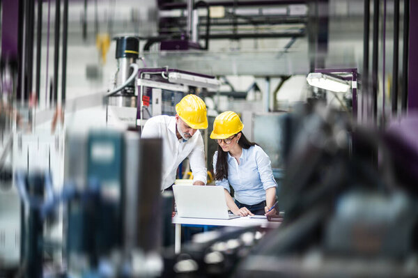 Two Project Managers Standing Modern Industrial Factory Looking Laptop Screen Royalty Free Stock Images