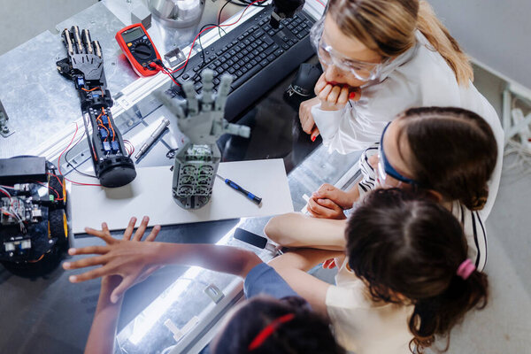 High Angle View Teacher Helping Girls Working Small Robot Building Royalty Free Stock Images